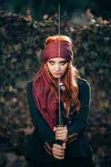 Outdoor portrait of young female in pirate costume. Halloween concept