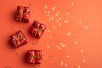 Red Christmas gifts on a red copyspace background. An article about the New year and Christmas. The choice of gifts.