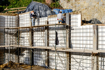 Construction worker on a scaffold working on a retaining wall