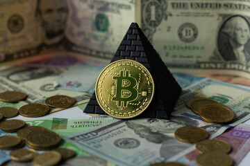 Bitcoin coin on a background of dollar bills and pyramids and Ukrainian money