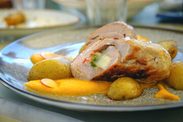 View at Pork Tenderloin with Carrot puree, baby potatoes sauteed with rosemary on grey plate