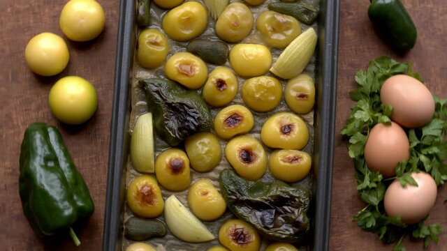 Roasted and raw ingredients to make shakshuka style dish made from tomatillo (husk tomato). 