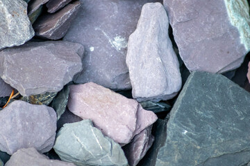 Raw rocks and minerals as natural stones background with crushed and rough material at a rough coast or rocky beach show nuggets and sandstones in harmonic pastel colors as natural mineral background