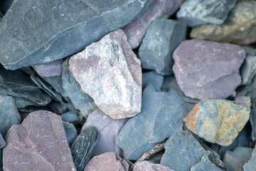 Raw rocks and minerals as natural stones background with crushed and rough material at a rough coast or rocky beach show nuggets and sandstones in harmonic pastel colors as natural mineral background