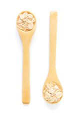Top view of dry rolled oatmeal in wooden spoon isolated on white background.