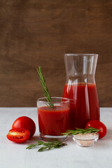 fresh Tomato juice with salt and rosemary. Bloody Mary cocktail with ingredients. Alcoholic drink with vodka and tomato juice in a glass isolated on a white background. copy space. vertical