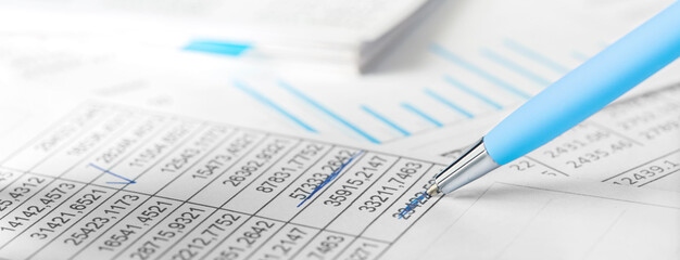 Accounting document with pen,color diagram and checking financial chart. Concept of banking, financial report and financial audit. In blue color.