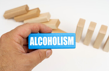 The man is holding a blue plaque with the inscription - ALCOHOLISM