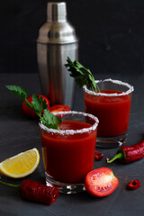 Tomato juice with salt. Bloody Mary cocktail with ingredients. Alcoholic drink with vodka and tomato juice in a glass isolated on a black background. vampiro cocktail with pepper on table. copy space.