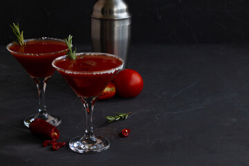 cocktail with cherry tomatoes.Bloody Mary cocktail. Alcoholic drink with vodka and tomato juice in a glass isolated on a black background. vampiro cocktail with pepper on a busy bar top. copy space.