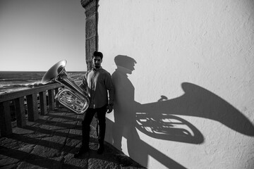 A musician man with a tuba on the Miramar beach, Porto, Portugal. Black and white photo.