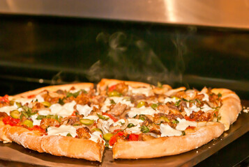 top view, close, medium distance of a finished pizza taken from oven and ready to be sliced, and eaten