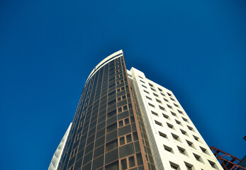 Obraz na płótnie Canvas Unfinished high-rise building against a bright blue sky