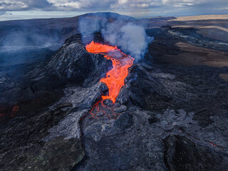 Lava flow from the crater opening of Fagradalsfjall volcano. View from above into the volcanic...