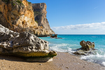 Obraz premium Mediterranean sea clear blue water and steep limestone cliffs travel Spain Cala Moraig Cumbre del Sol