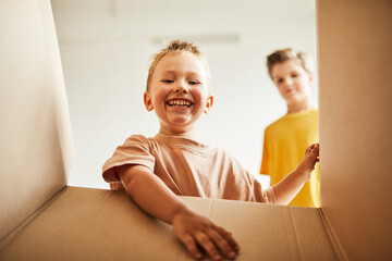 From the box shot of two boys unpacking while family moving to new house, copy space
