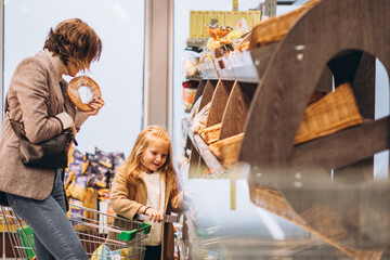 Mother with child choosing bread at a grocery store