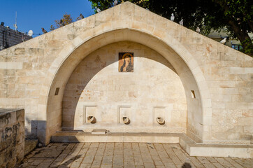 Mary's Well in Nazareth surrounded by pigeons. Nazareth, Israel. - obrazy, fototapety, plakaty