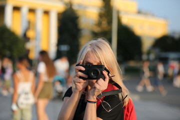 A woman takes pictures on the street in the city