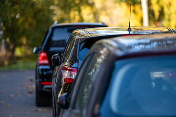 car row in a parking lot near an apartment house on a sunny autumn day, rear view, close-up
