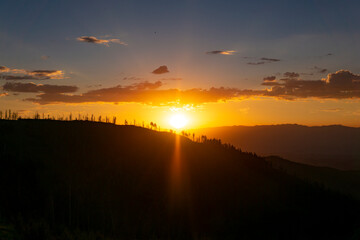 Obraz premium Stunning Golden Sunrise Over Silhouette Mountains