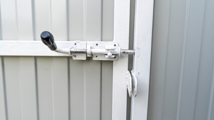 Outdoor garden fence building, new installed base frame with supports for a new metal fence in perspective against the background trees and green grass on summer day