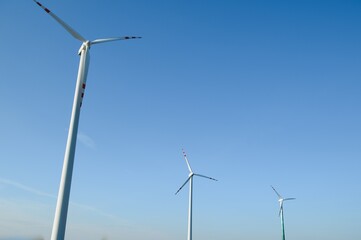 Wind Turbines in a Green Field and Blue Sky.