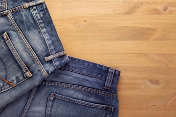 Blue jeans denim pocket on wood table. Jeans heap at wood background texture