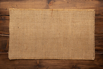 Burlap hessian sacking texture on wooden background