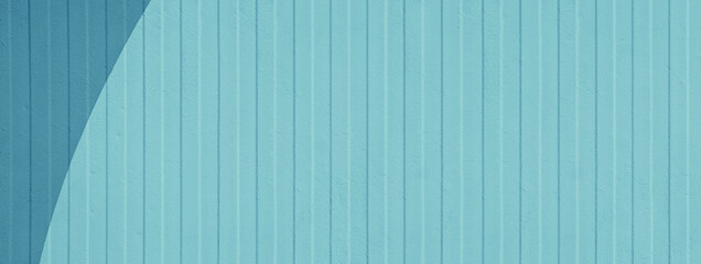 Painted exterior panel. Cyan wall vertical striped walls with blue painted geometric shape. 