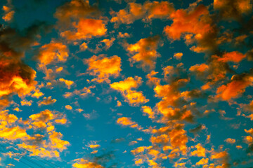 Obraz na płótnie Canvas Dramatic orange clouds at sunset. Cloudscape abstract background photo.