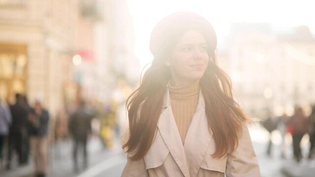Slow motion of attractive read head woman. Happy smiling young woman walking down the sunny street. High quality 4k footage