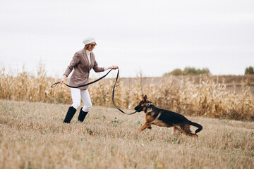 Beautiful woman walking out her dog in a field