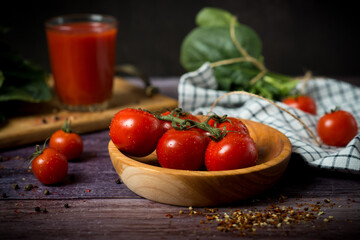 cherry tomatoes and tomato juice on a black background