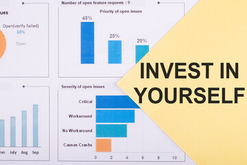 Business concept. Yellow paper with text Invest in Yourself on financial graphs