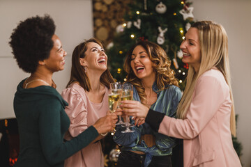 Four Multi ethnic Female Friends Having Fun And Make Toast As They Celebrate At Home Christmas Party