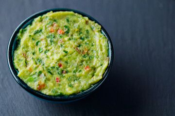 Guacamole on a dark background. Traditional mexican dip sauce guacamole in bowl. Traditional...