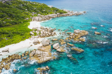 Aerial view of Seychelles tropical Marron beach at La Digue island. White sand beach with turquoise ocean water and quaint granite rocks. tropical paradise