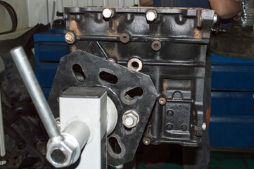 Fototapeta na wymiar The three-cylinder engine block is fixed on the engine repair stand