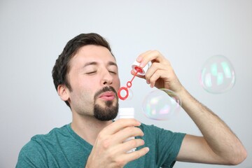 Caucasian man blowing soap bubbles