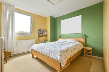 Interior shot of a bedroom with a queen-sized bed and a green-colored wall