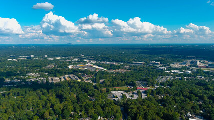 a stunning aerial shot of vast miles of lush green trees with a view of the buildings nestled in...