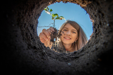 Girl holding tree seedling - planting forest