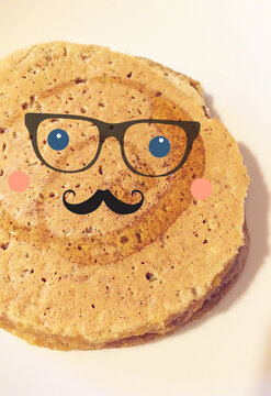 round pancake with a cute cheerful face, with a mustache and glasses