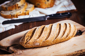 Loaf of sourdough bread on a rustic wooden background in autumn mood