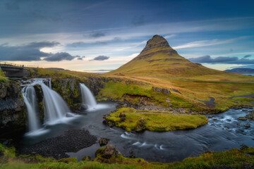 Landschaft im Westen Islands. Kirkjufell-Berg und Kirkjufellsfoss-Wasserfall bei schönem Sonnenuntergang. Berühmte isländische Naturansicht, gelegen auf der Halbinsel Snaefellsnes (Snæfellsnes).