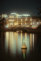 Illuminated building reflected in the water in city center Moscow, Russia at night