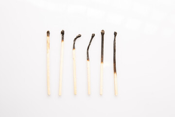 six burnt wooden matches on white background