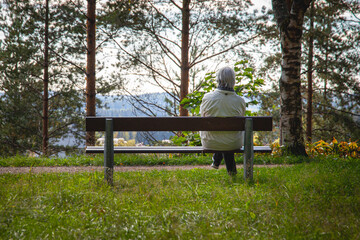 Man from behind sitting in a park bench