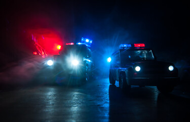 Obraz na płótnie Canvas Police cars at night. Police car chasing a car at night with fog background. 911 Emergency response police car speeding to scene of crime.